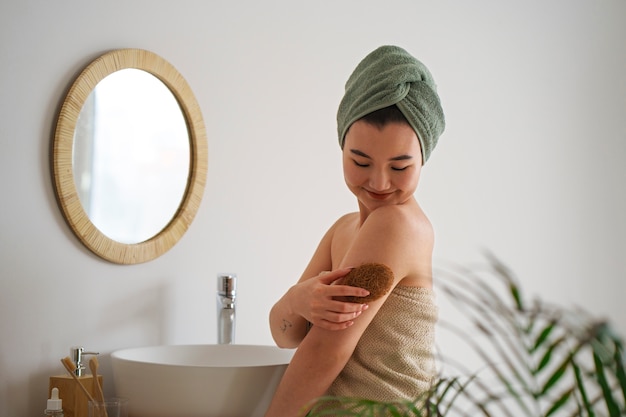 Foto gratuita donna del colpo medio che si esercita nella cura di sé