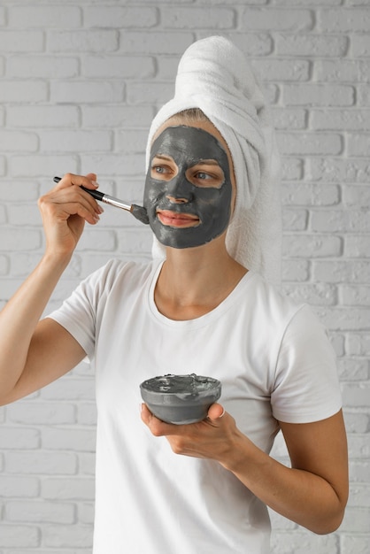 Free photo medium shot woman putting on face remedy