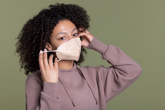 Free photo medium shot woman putting on ffp2 mask