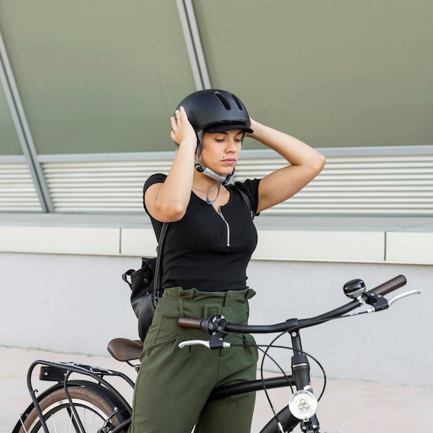 Medium shot woman putting on helmet