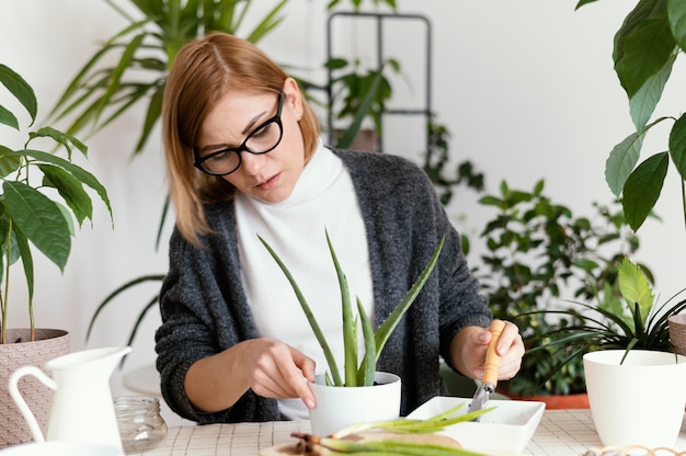 Medium shot woman putting soil in pot