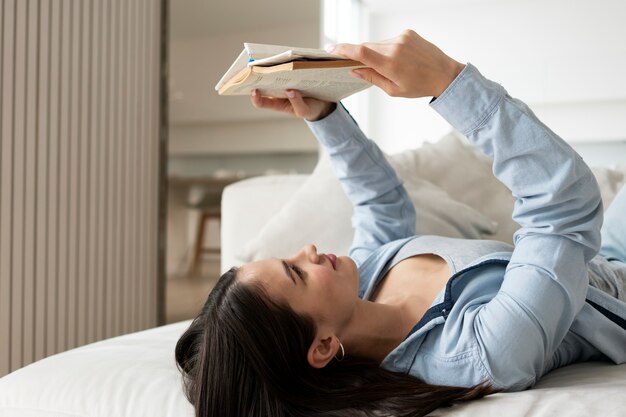 Medium shot woman reading in bed