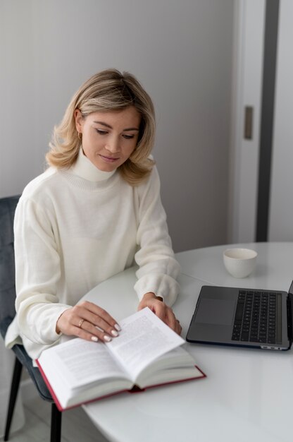 Medium shot woman reading book