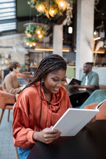 Medium shot woman reading in coffee shop