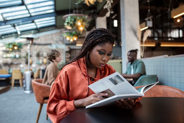 Medium shot woman reading in coffee shop