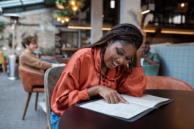 Medium shot woman reading in coffee shop