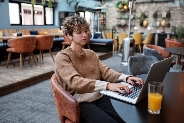 Free photo medium shot woman reading in coffee shop