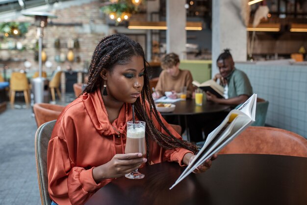 Medium shot woman reading in coffee shop