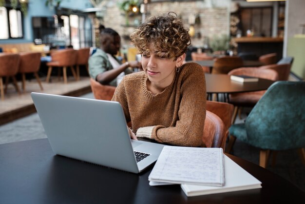 Medium shot woman reading in coffee shop