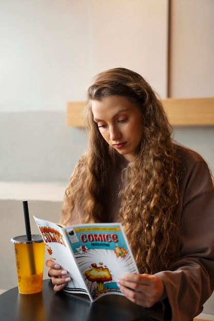 Free photo medium shot woman reading comics