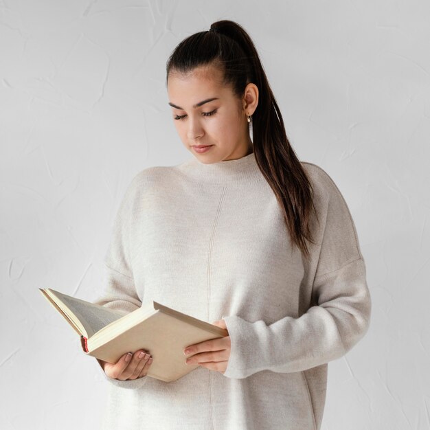 Medium shot woman reading indoors