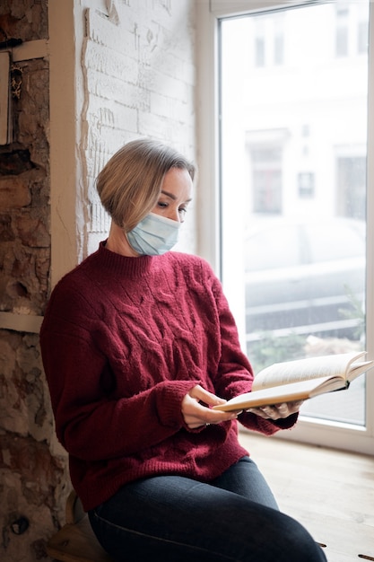 Medium shot woman reading indoors