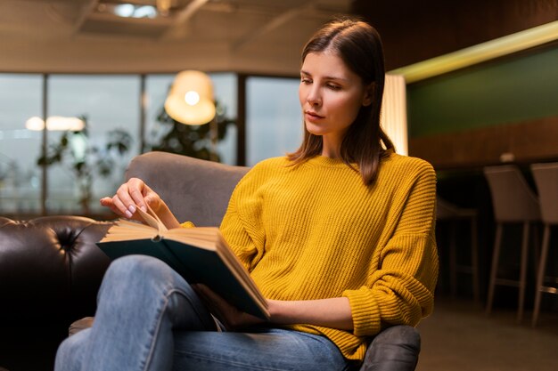 Medium shot woman reading indoors