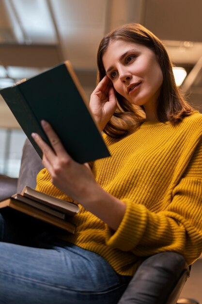 Medium shot woman reading indoors
