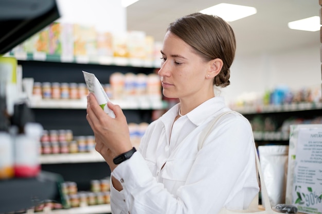 Medium shot woman reading label