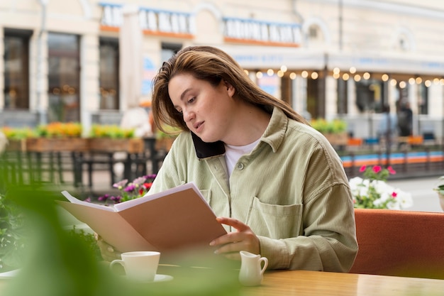 ミディアムショットの女性の読書メニュー