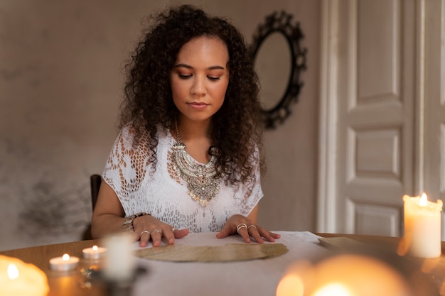 Free photo medium shot woman reading tarot at home