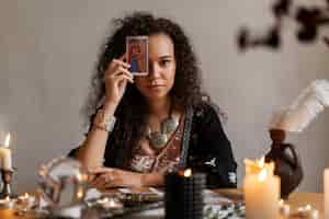 Free photo medium shot woman reading tarot at home