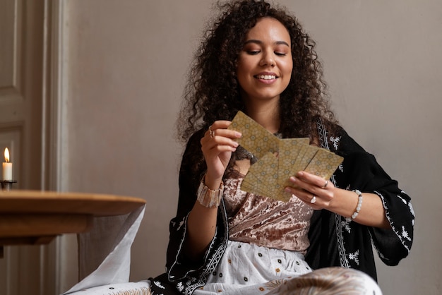 Free photo medium shot woman reading tarot at table