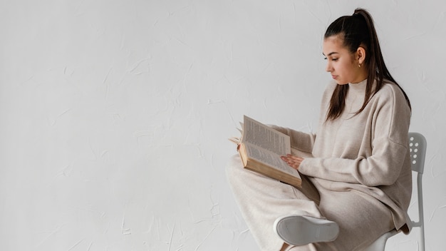 Medium shot woman reading with copy space