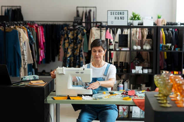 Medium shot woman repairing fashion goods