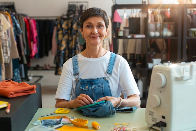 Бесплатное фото Женщина среднего роста ремонтирует модные товары
