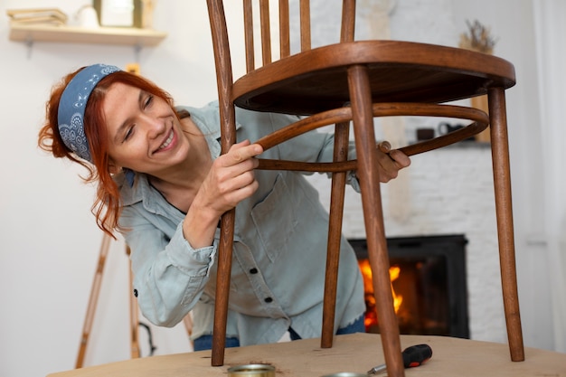 Бесплатное фото Женщина среднего роста восстанавливает мебель