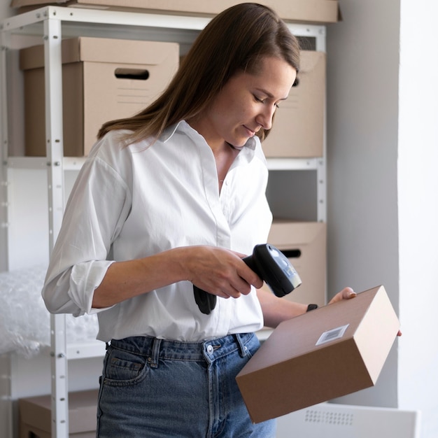 Medium shot woman scanning box