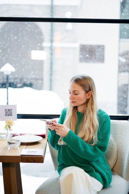 無料写真 レストランでqrコードをスキャンするミディアムショットの女性