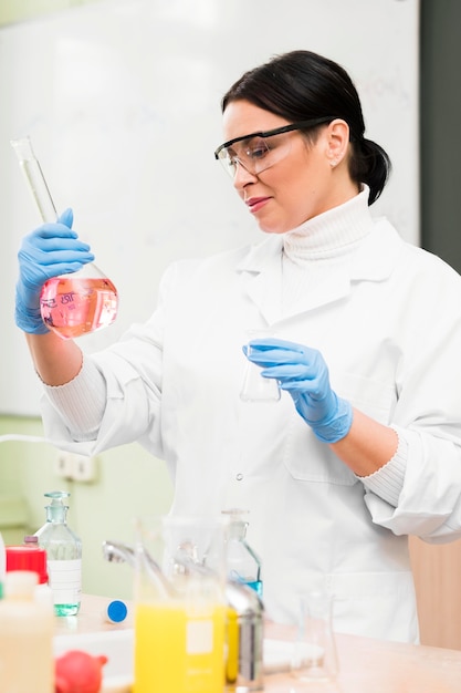 Foto gratuita scienziato della donna del colpo medio con la boccetta