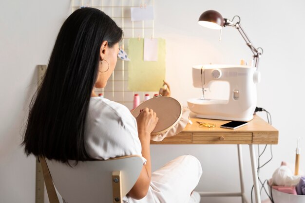 Medium shot woman sewing at home