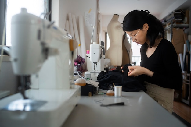 Free photo medium shot woman sewing inside