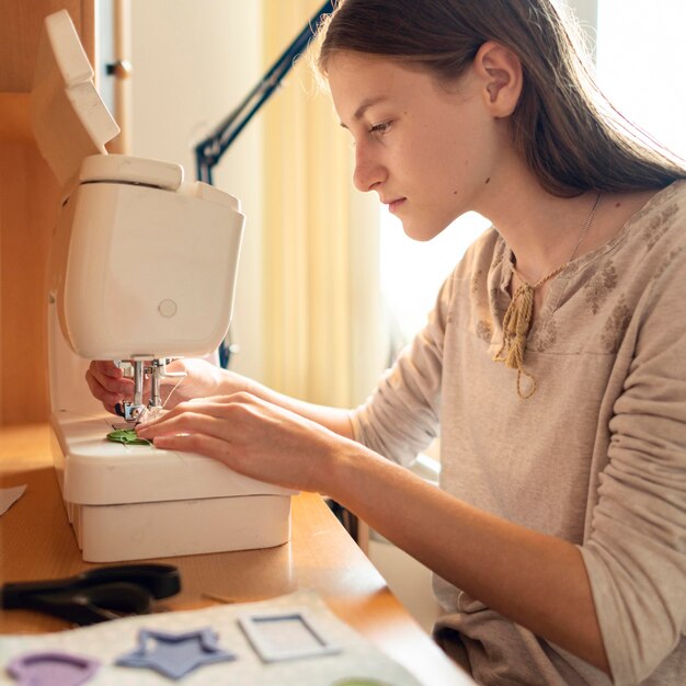 Medium shot woman sewing material