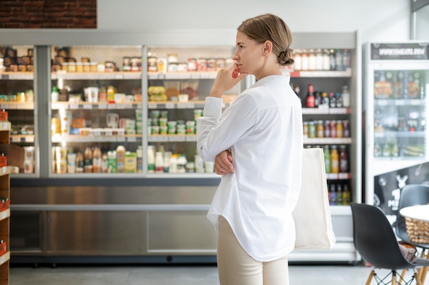 Medium shot woman at shop thinking