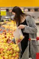 Foto gratuita donna del colpo medio che acquista la frutta