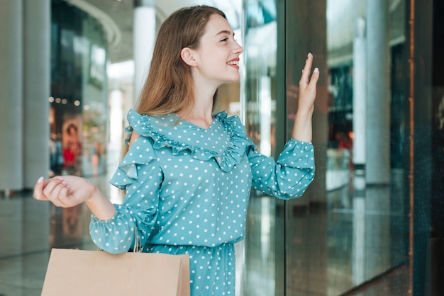 Medium shot woman at shopping mall waving