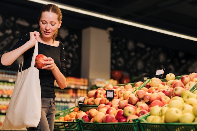 Medium shot woman shopping for pomegranate