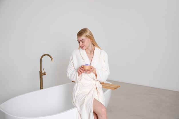 Colpo medio donna seduta sulla vasca da bagno