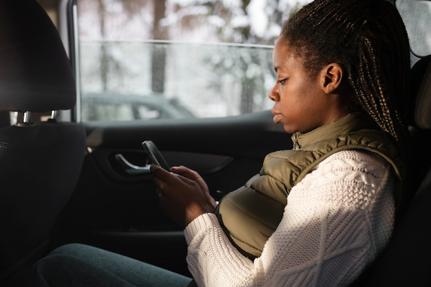 Free photo medium shot woman sitting in car