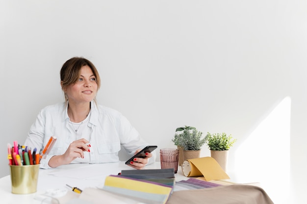 Foto gratuita donna del colpo medio che si siede allo scrittorio