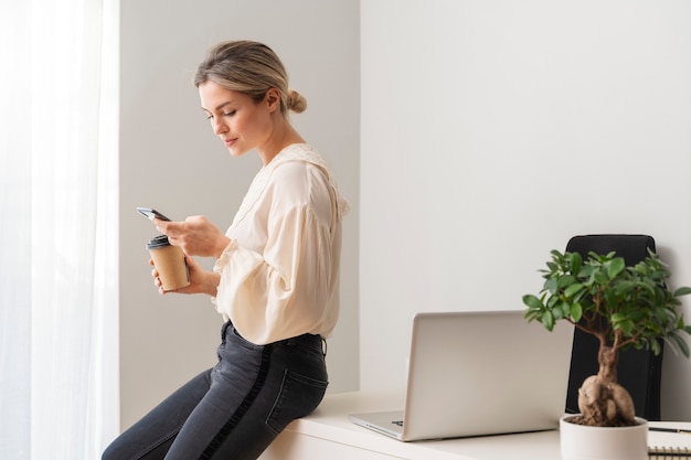 Medium shot woman sitting on desk