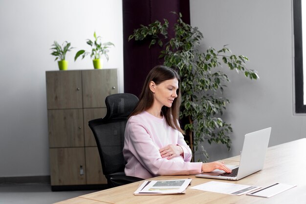 Medium shot woman sitting at desk