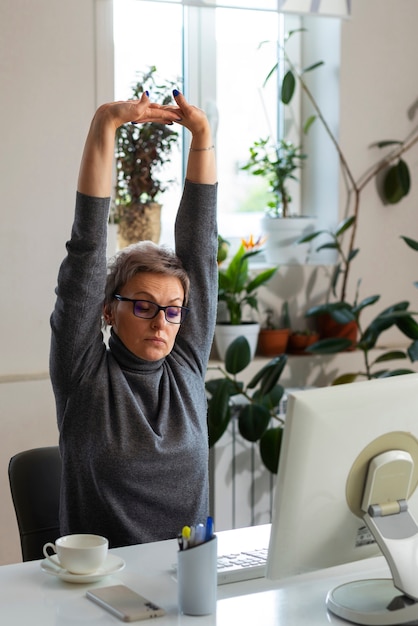 Free photo medium shot woman sitting at desk