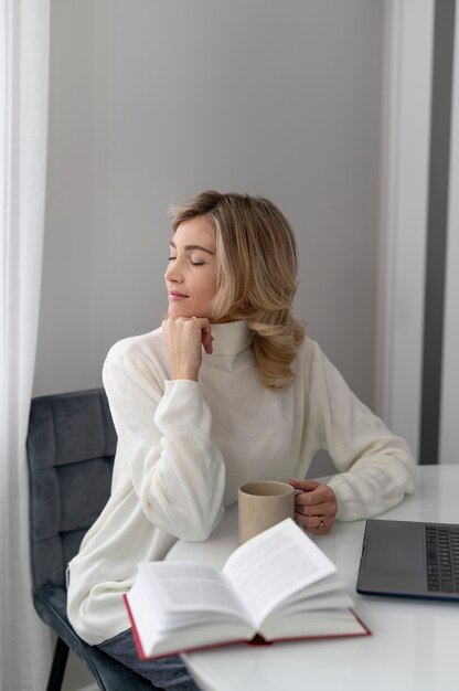 Medium shot woman sitting at home