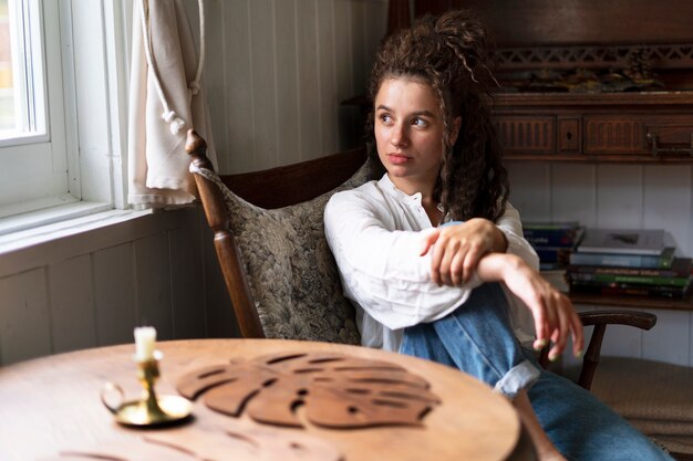 Medium shot woman sitting indoors