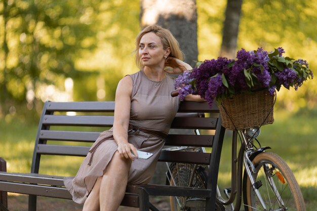 Medium shot woman sitting near bicycle