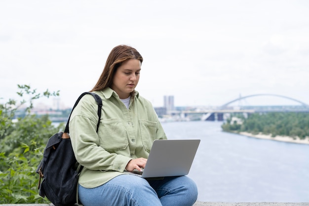 Medium shot woman sitting with laptop