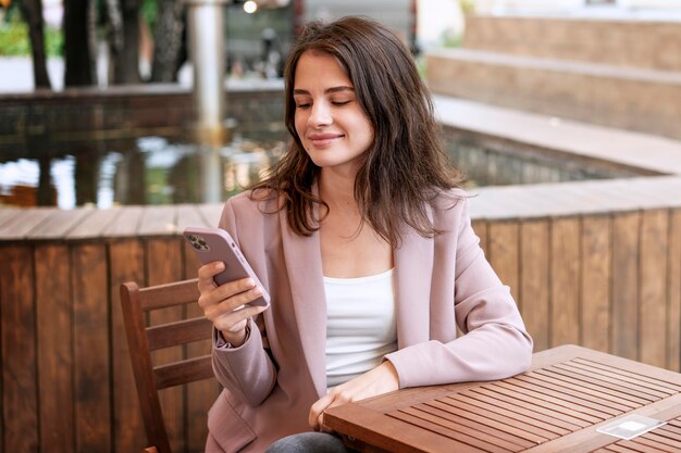 Medium shot woman sitting with phone