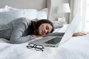 Free photo medium shot woman sleeping near laptop