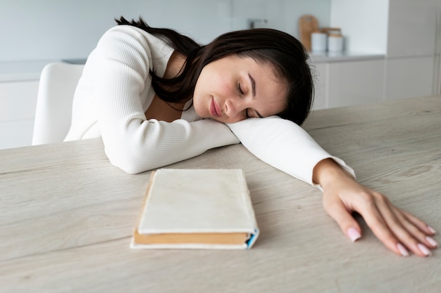 Medium shot woman sleeping on table